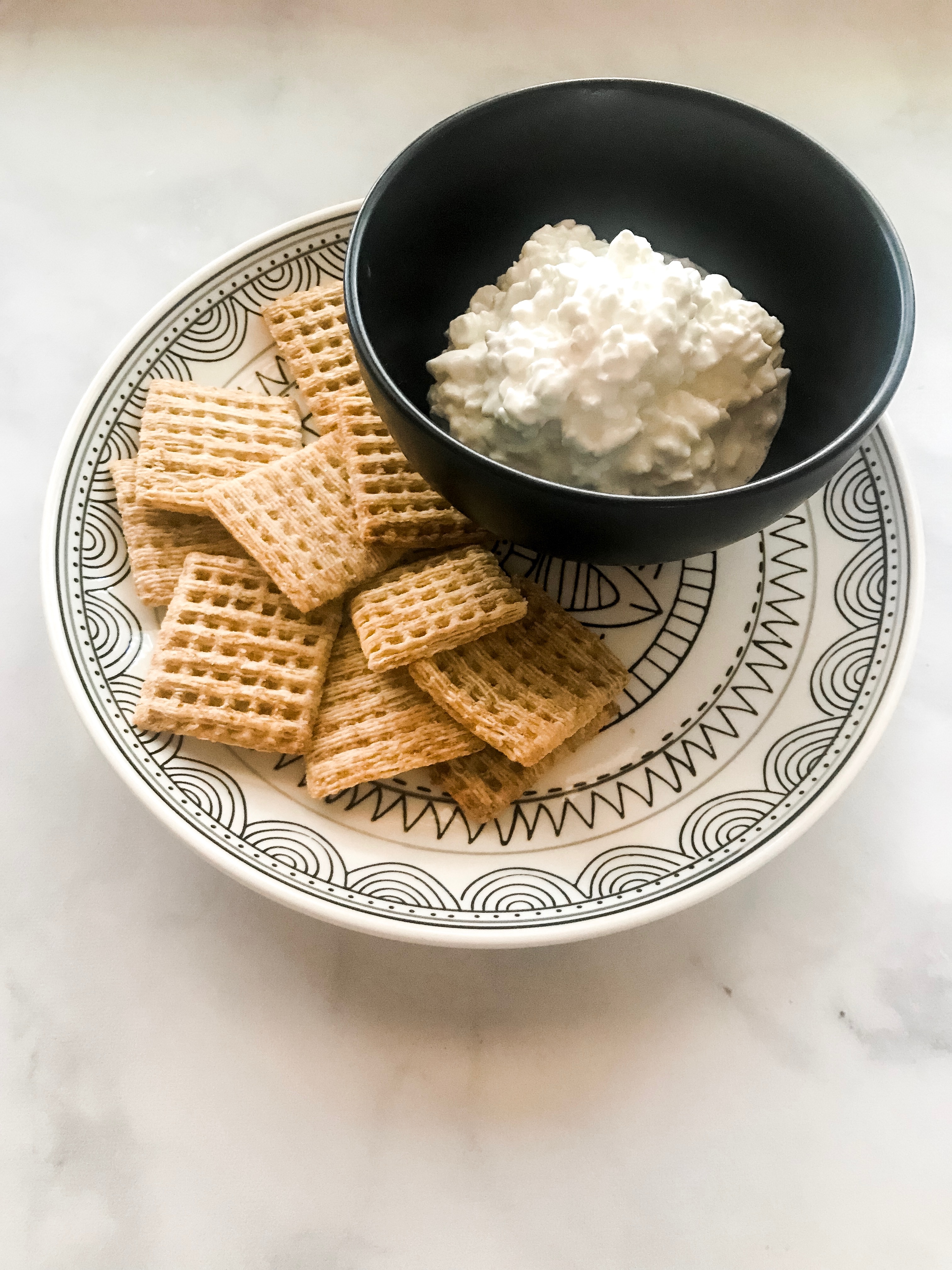 Plate with crackers and bowl with cottage cheese