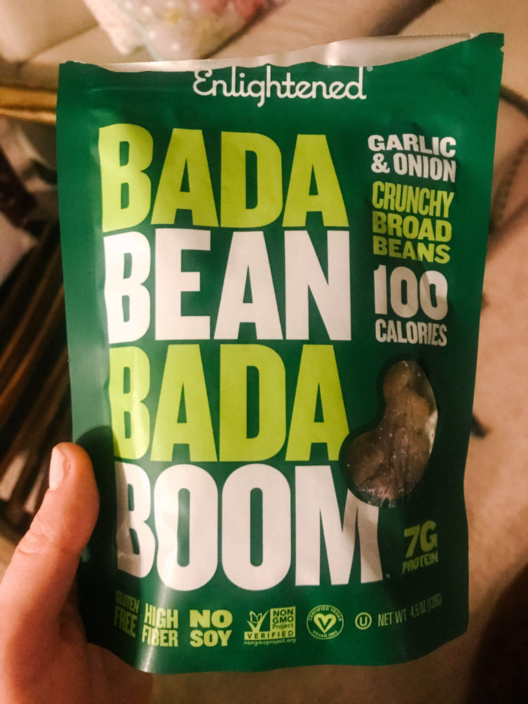 Jen Lyman holding a bag of Bada Bean Bada Boom broad bean snack