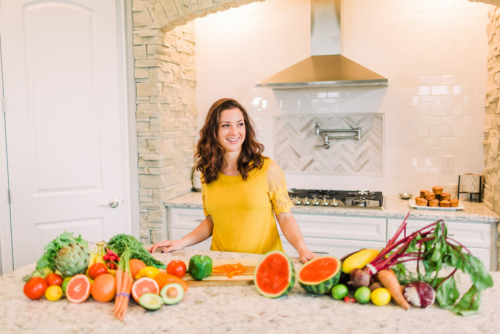 Jen Lyman, dietitian at New Leaf Nutrition, behind an array of colorful fruits and vegetables