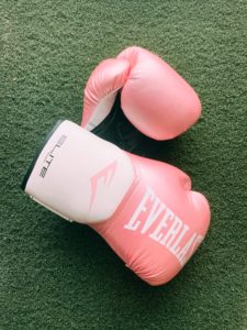 Pink Everlast boxing gloves on green turf