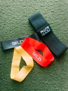 Red, yellow, and black resistance bands on green turf